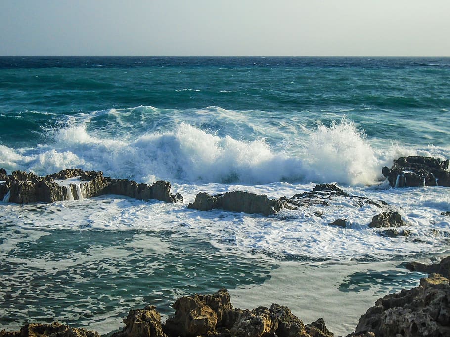 Волны разбиваются о берег. Резкий берег. Набегающая волна. Мелкие волны на фоне скалистого берега. Набегающая волна фото.