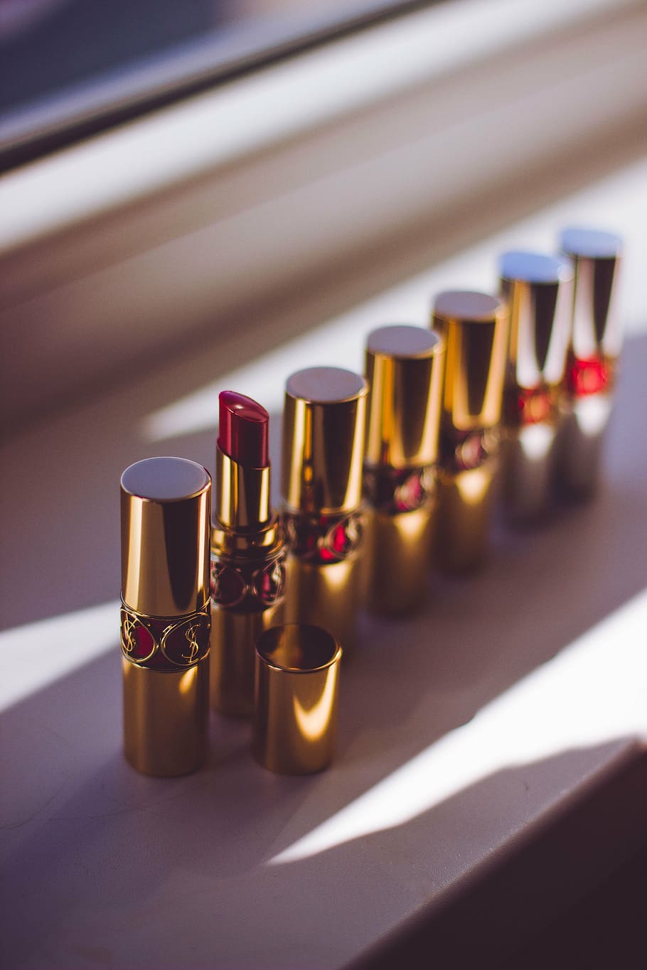red, lipsticks, standing, window, lipstick, lipstick tubes, makeup, in a row, close-up, indoors