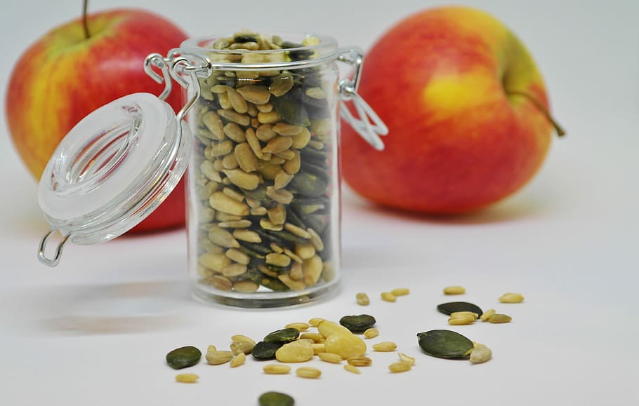 clear, glass jar, two, apples, apple, sunflower seeds, pumpkin seeds, pine nuts, fruit, food