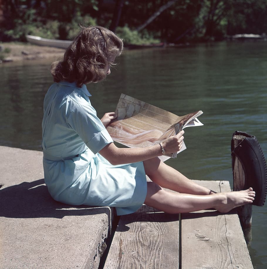 woman, sitting, wooden, dock, holding, magazine, rive, reading, people, girl