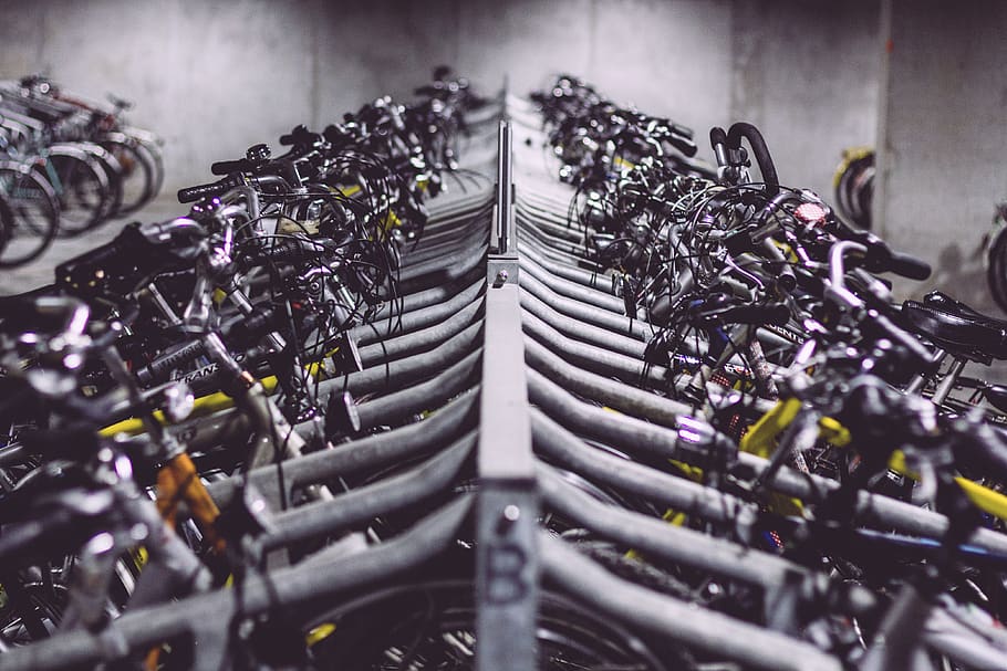 bikes, bicycles, bike racks, selective focus, indoors, in a row, large group of objects, abundance, bicycle, metal
