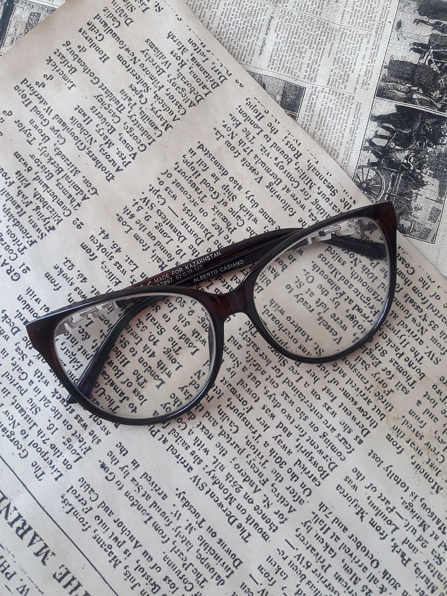 black, framed, wayfarer-style sunglasses, top, newspaper, paper, book, the text of the, document, glasses