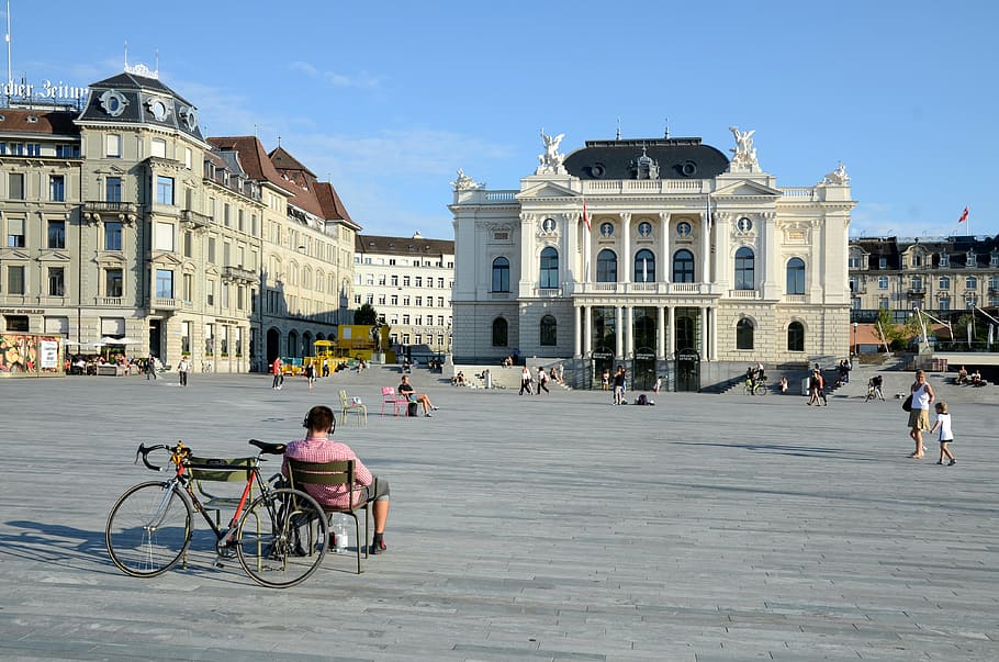 man, sitting, chair, facing, beige, building, zurich opera house, sechseläutenplatz, zurich, switzerland