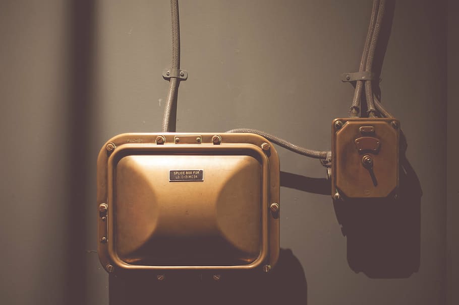 close-up photo, square device, gold, brown, container, wires, metro, technical, hanging, indoors