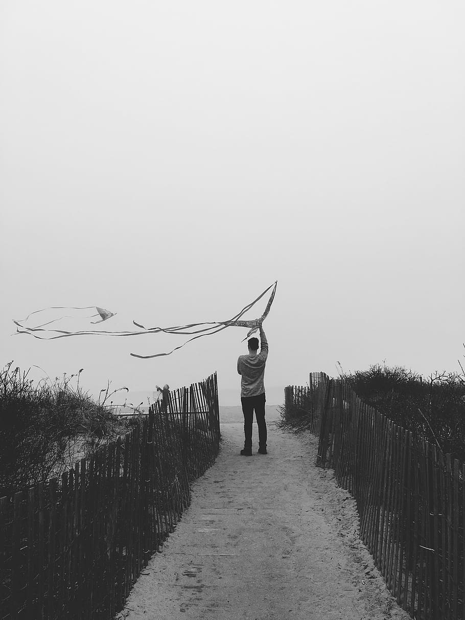 grayscale photography, man, standing, fences, people, kite, black, white, black and white, monochrome