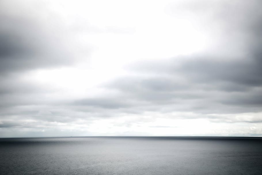 grayscale photo, calm, body, water, white, cloudy, sky, daytime, ocean, sea
