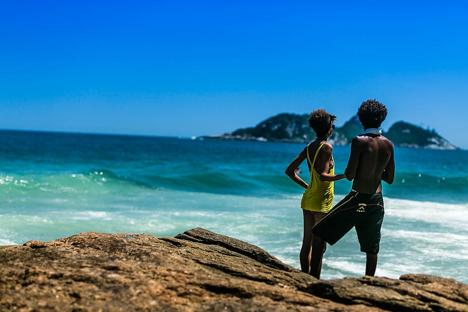 boys near shoreline, man, woman, standing, behind, ocean, daytime, sea, water, waves