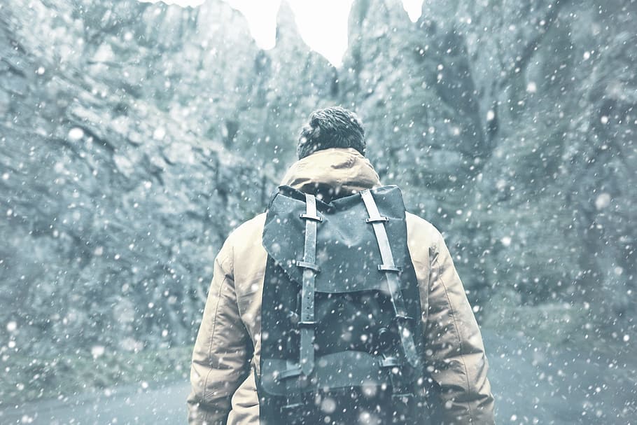 man, black, backpack, walking, rock formations, jacket, winter, snow, cold, ice