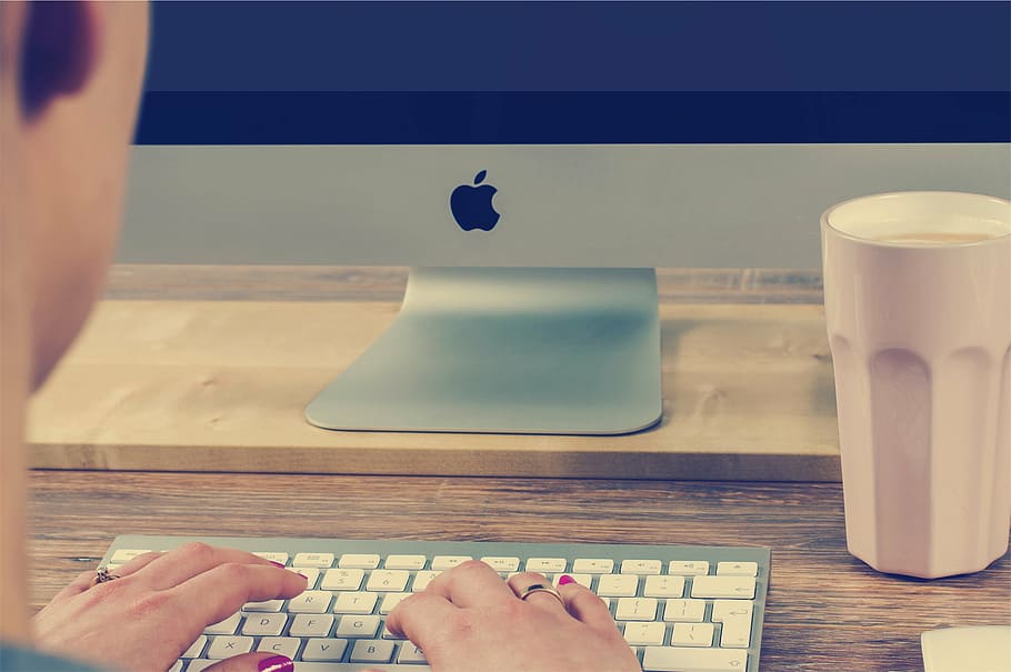 pessoa mão, teclado Apple, prata, Imac, monitor, maçã, sem fio, teclado, perto, copo