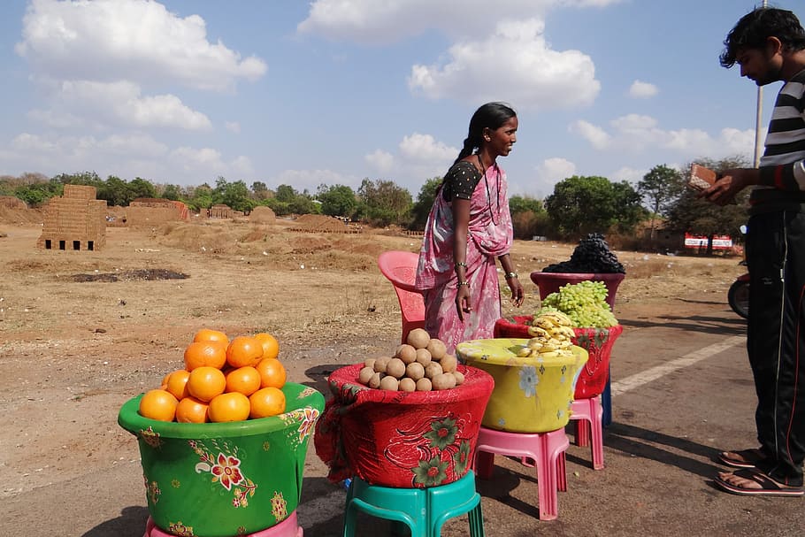 man, standing, front woman, wearing, pink, dress, Fruit, Vendor, Dharwad, India