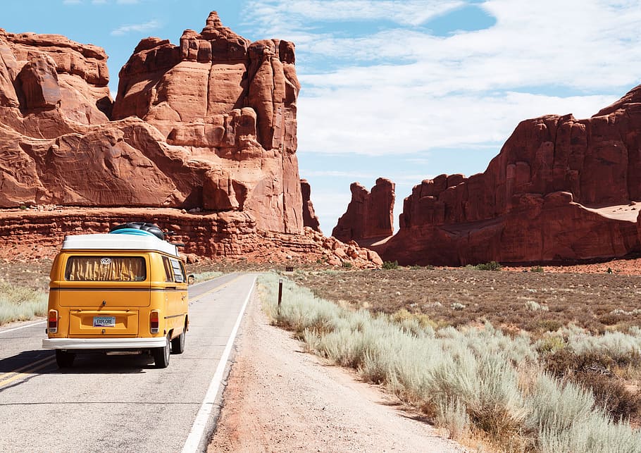 yellow, van, traveling, concrete, road, towards, red, rock monoliths, daytime, arches national park