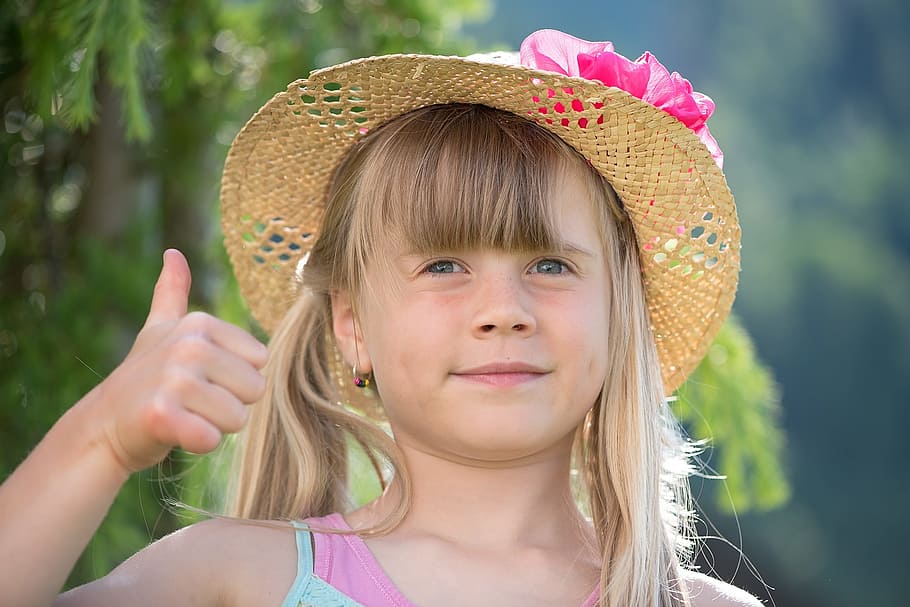 niño pequeño, vistiendo, marrón, rosado, soleado, sombrero, verde azulado, arriba, mostrando, pulgar derecho