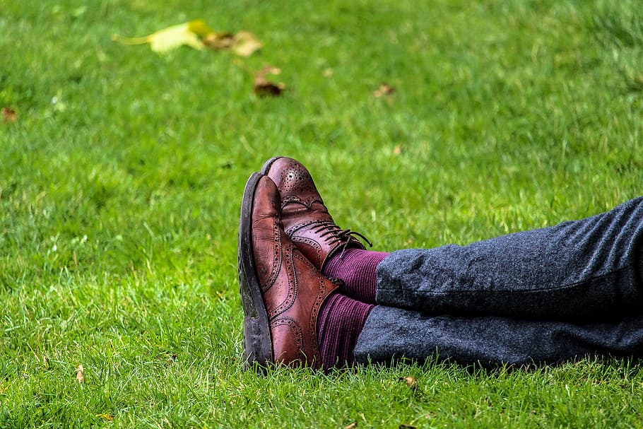 person, wearing, pair, brown, leather wingtip oxford shoes, sitting, green, grass, leather, wingtip