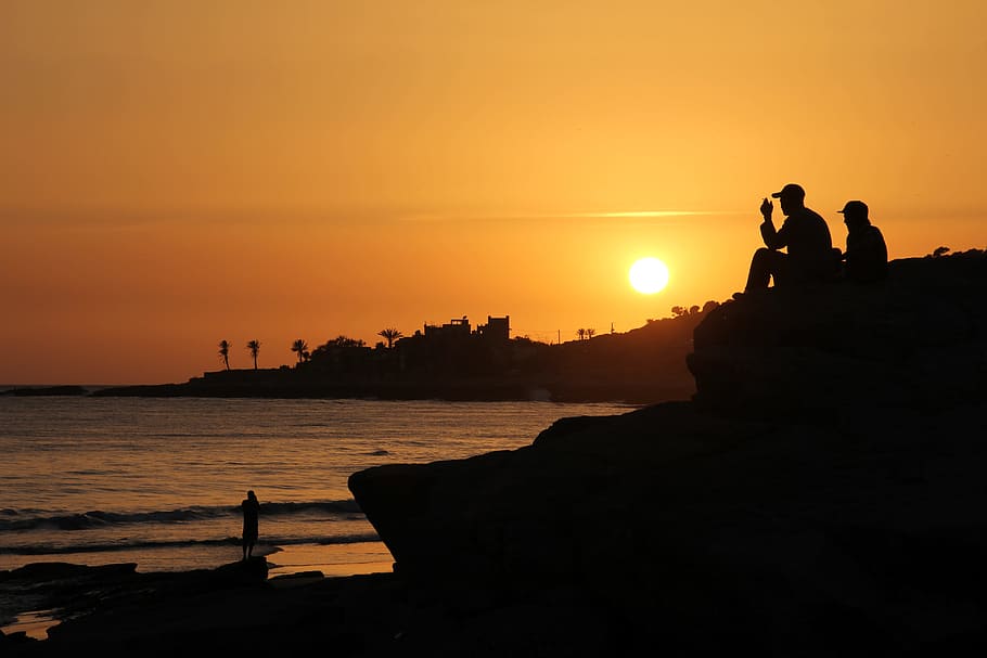 fotografía de silueta, dos, personas, Marruecos, Taghazout, playa, puesta de sol, agua, costa, luz de fondo