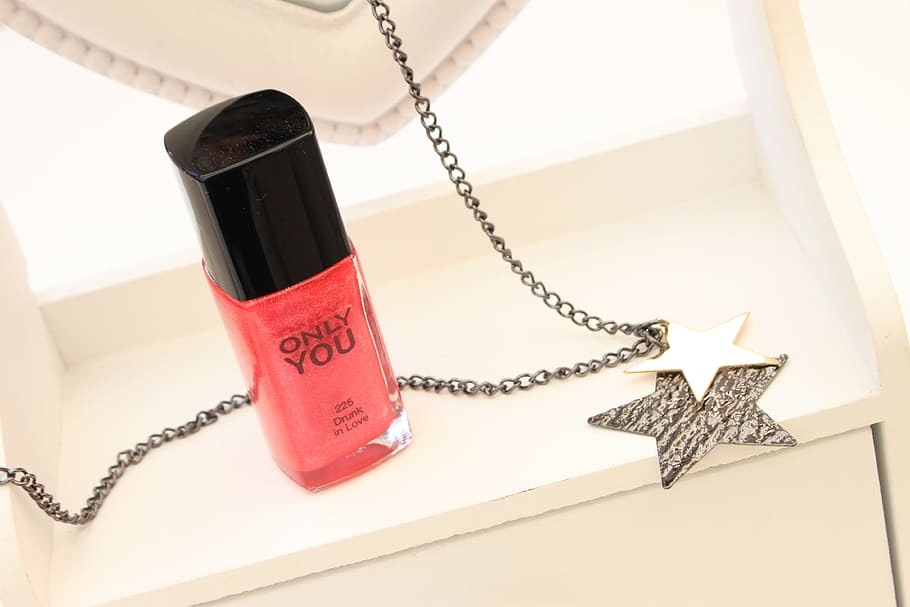 liquid lipstick container, nail polish, necklace, jewelry, makeup, pink, communication, indoors, chain, telephone