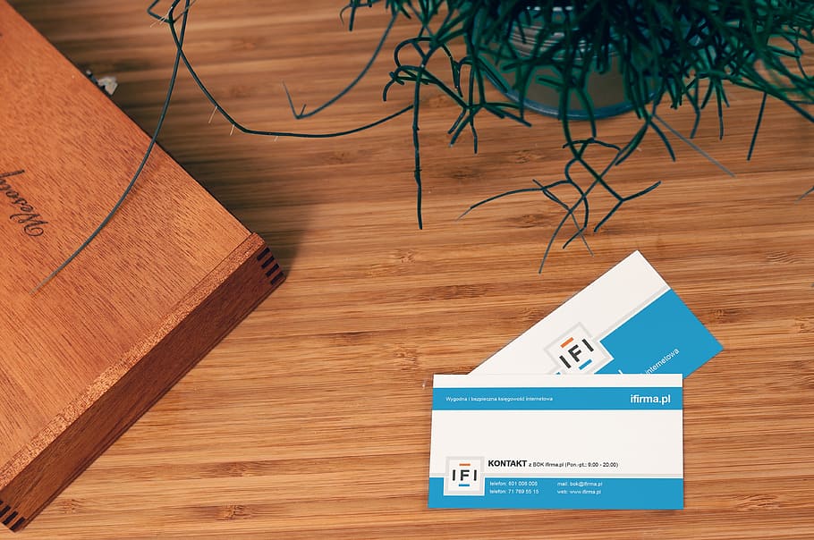 two, white-and-blue cards, brown, wooden, surface, business card, company, address, name, logo