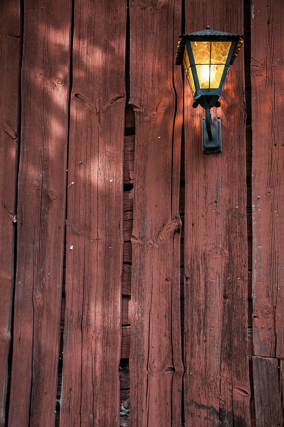 turn-on, black, post lamp, red wood paint, plank, closeup, texture, wood, weathered, barn