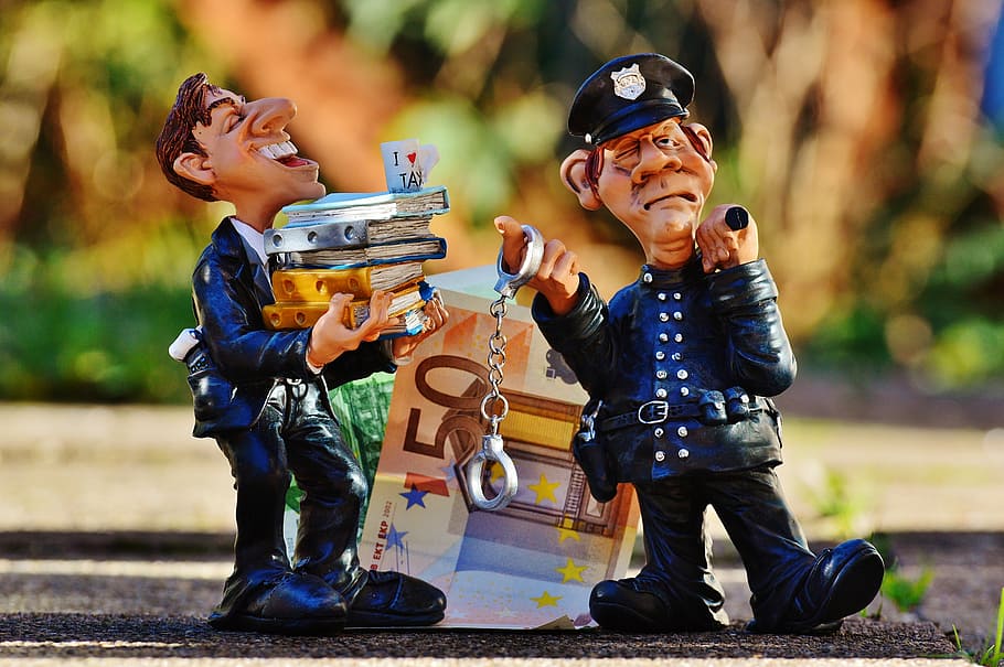 man, holding, stock, books, policeman, handcuffs, 50 euro figurine, taxes, tax evasion, police