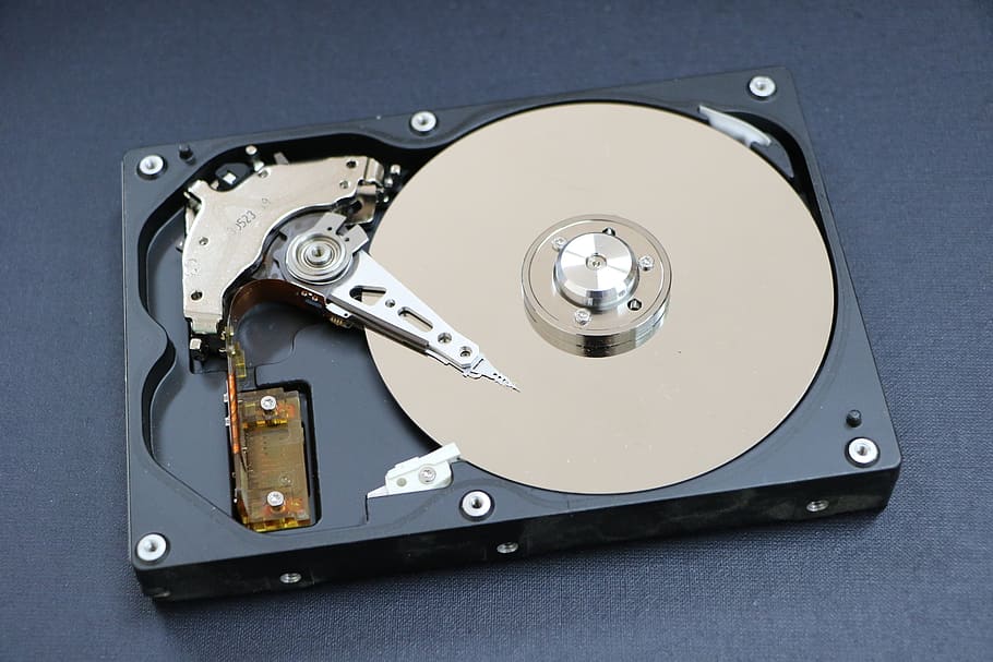 black, beige, hard, disk drive, placed, gray, surface, hard disk, a hard disk drive, an auxiliary storage device