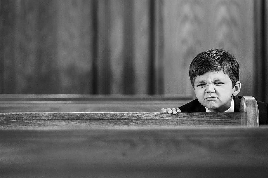 grayscale photography, boy, sitting, pew, face, wrinkle, expression, emotion, church, child