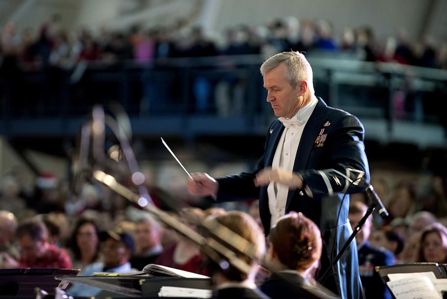 shallow, focus photo, man, formal, suit, conducting, concert, band, orchestra, conductor
