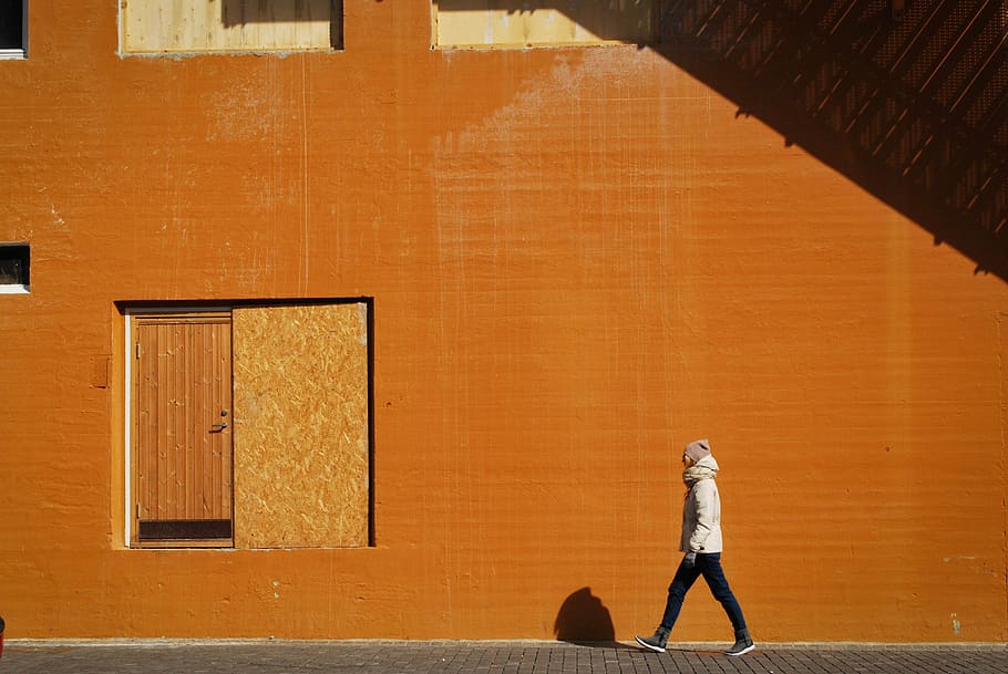 person, walking, street, orange, structure, near, brown, building, woman, girl