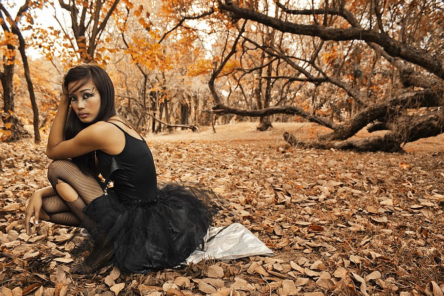 mulher, sentado, chão, floresta, sépia, fotografia, vestindo, preto, sem mangas, mini