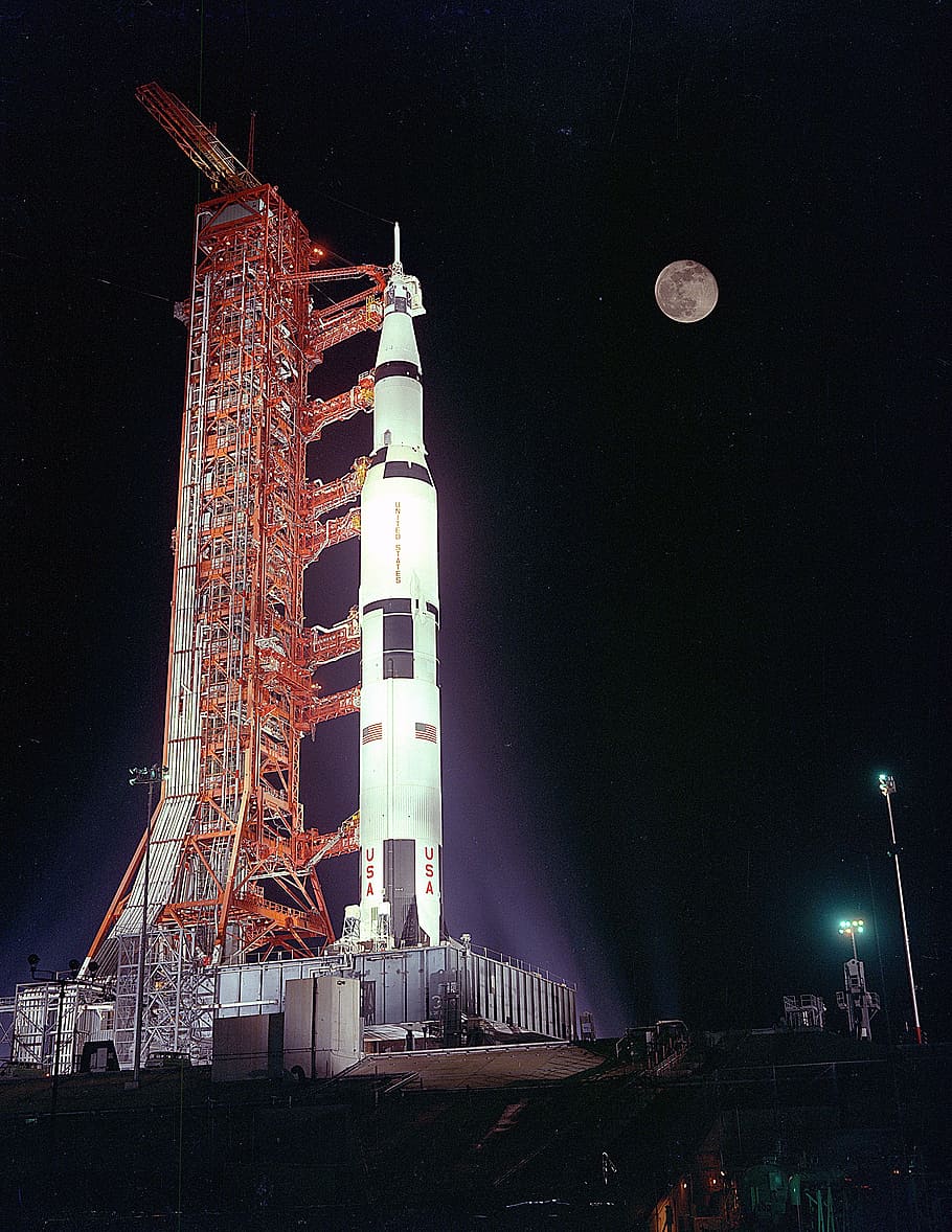 wide, angle photo, white, rocket, apollo 17, launch pad, pre-launch, night, full moon, manned mission