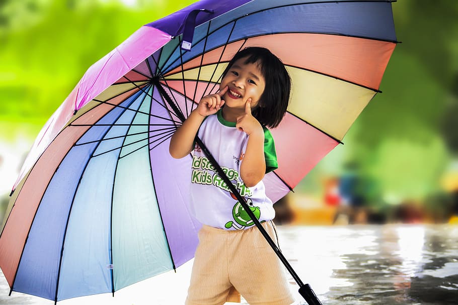 girl, white, green, crew-neck t-shirt, brown, shorts outfit, smiling, holding, multicolored, umbrella