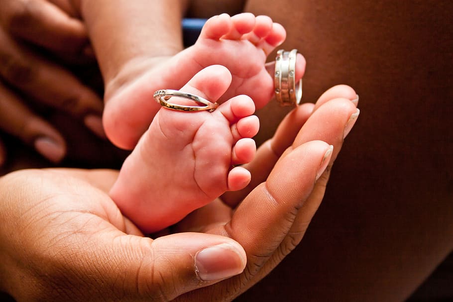 silver-colored ring, pregnancy, baby feet, baby toes, newborn, baby, child, infant, parent, family