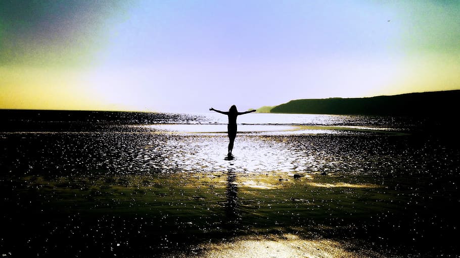 silhouette photography, person, standing, arms, wide, open, surrounded, body, water, golden