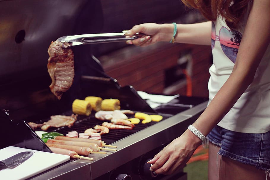 woman, white, top, blue, short, shorts, holding, tongs, grilled, steak
