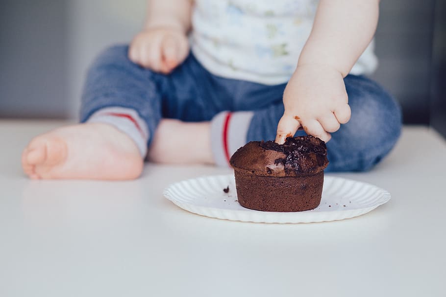 toddler, putting, finger, chocolate muffin, food, drinks, people, baby, birthday, child