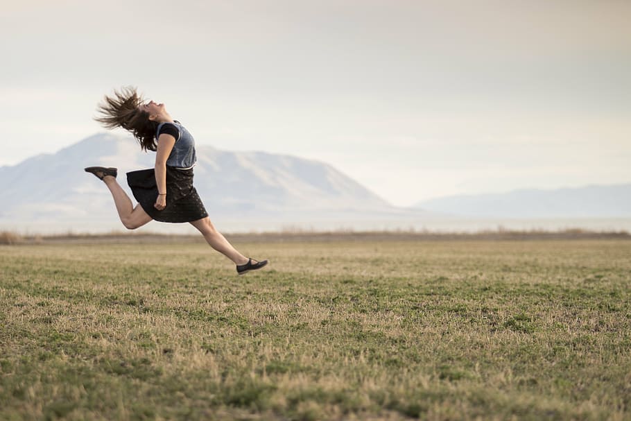 woman, wearing, black, gray, mini dress, grass field, girl, jumping, happy, smiling
