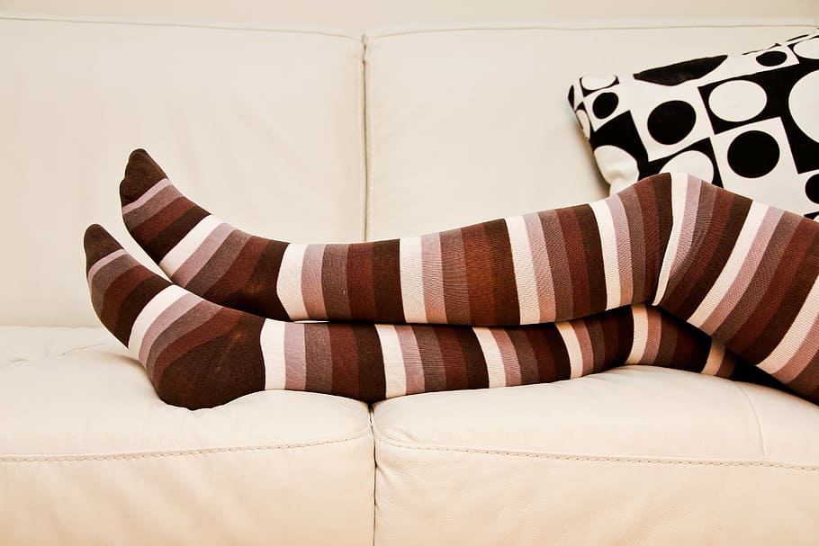 person, wearing, brown-black-and-white, striped, knee, high, socks, stripped socks, long socks, crossed legs
