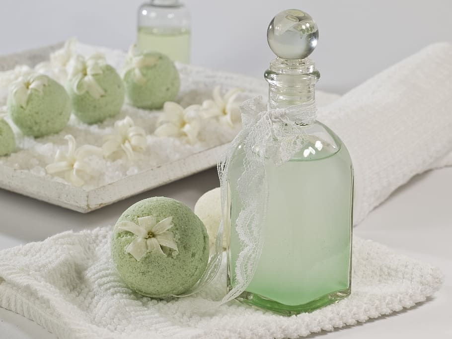 clear, glass bottle, green, cake, pops, placed, white, knitted, textile, bath balls