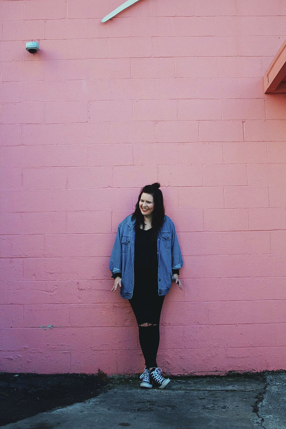 smiling, woman, leaning, pink, concrete, wall, daytime, people, fashion, denim