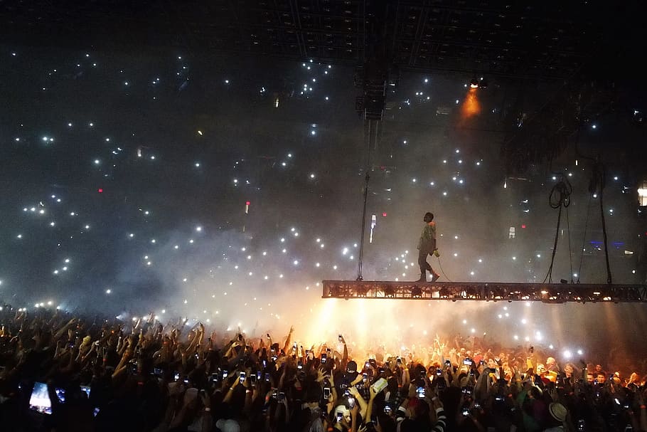 man, standing, steel platform, concert, surrounded, people, crowd, singer, singing, performance