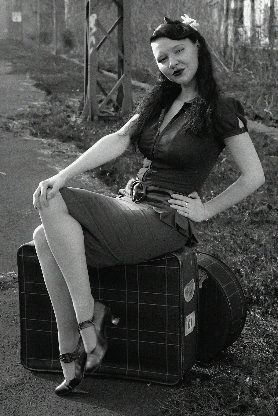 grayscale photography, woman, wearing, mini dress, sitting, luggage, pin up, black and white, retro, nostalgic