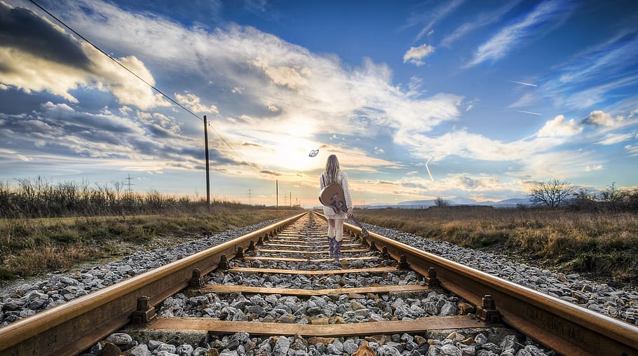 woman, wearing, white, dress, holding, guitar, walking, brown, steel train rail road, rail