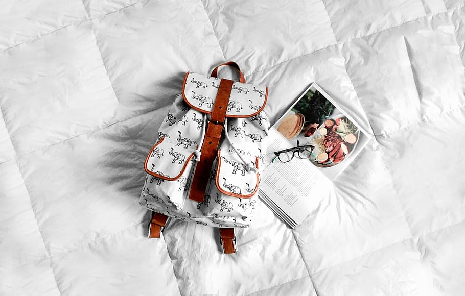 blanco, marrón, mochila de cuero, textil, al lado, libro, cama, bolso, mochila, gafas