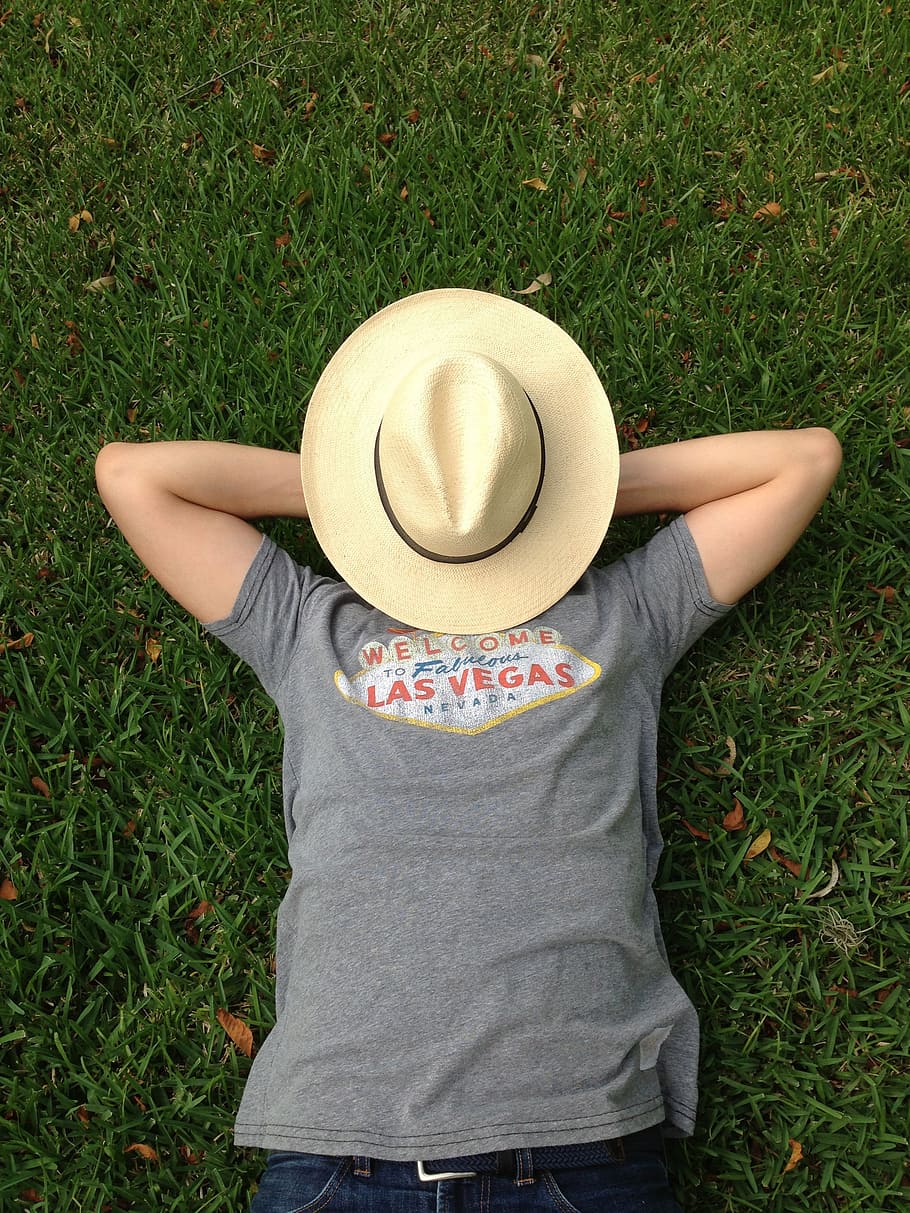 person, gray, shirt, lying, grass field, brown, sun hat, face, grass, summer