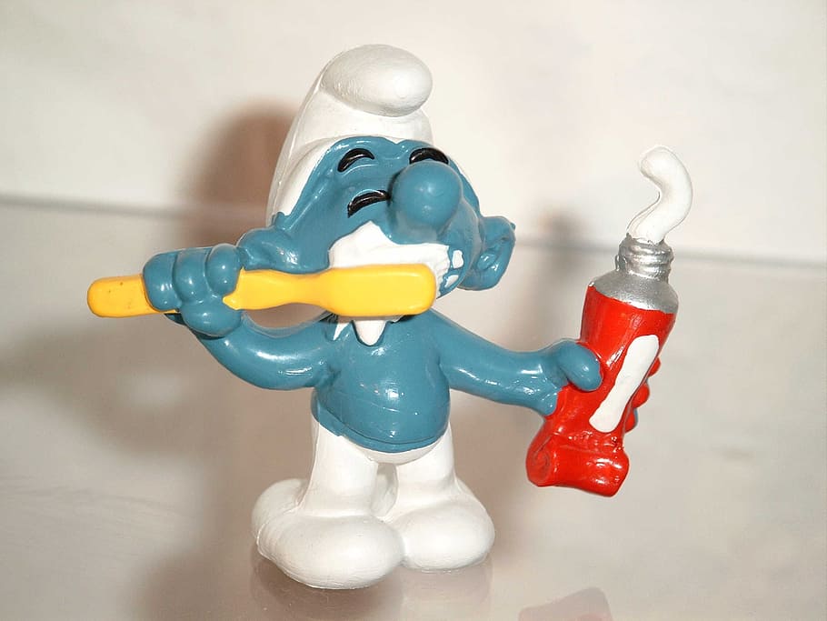 holding, toothpaste figurine, Smurf, Toothbrush, Toothpaste, toy, red, indoors, yellow, close-up