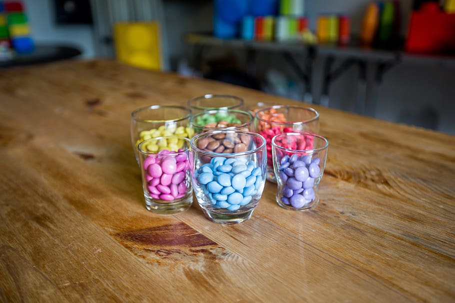 smarties, colorful, blue, red, purple, yellow, wooden table, table, indoors, still life