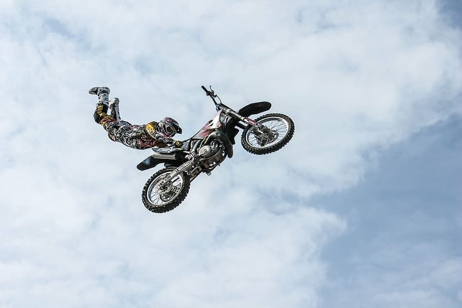 man, wearing, motocross gear, superman stunt, mid, air, biker, motorcycle, stunt, person
