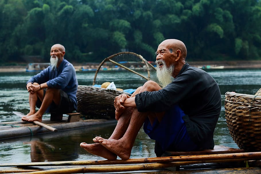 white, beaded, man, wearing, black, top, blue, short, ride-on bamboo, fisherman