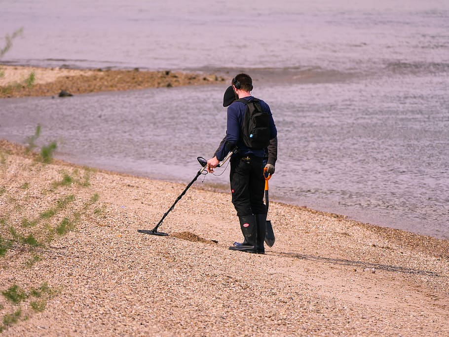 man, using, metal detector, holding, shovel, walking, beach, treasure hunt, probe, search