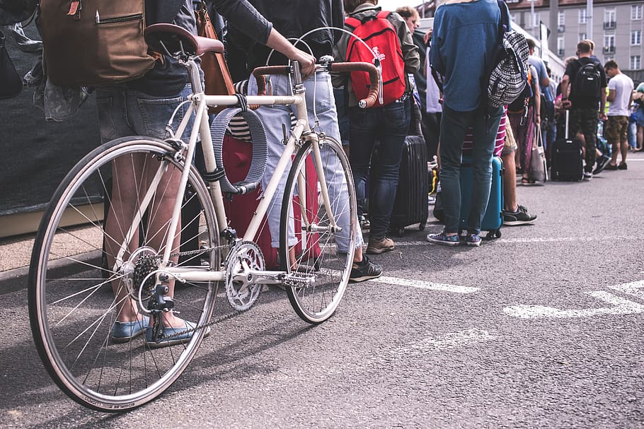 people, men, women, crowd, street, line, travel, bag, bike, bicycle
