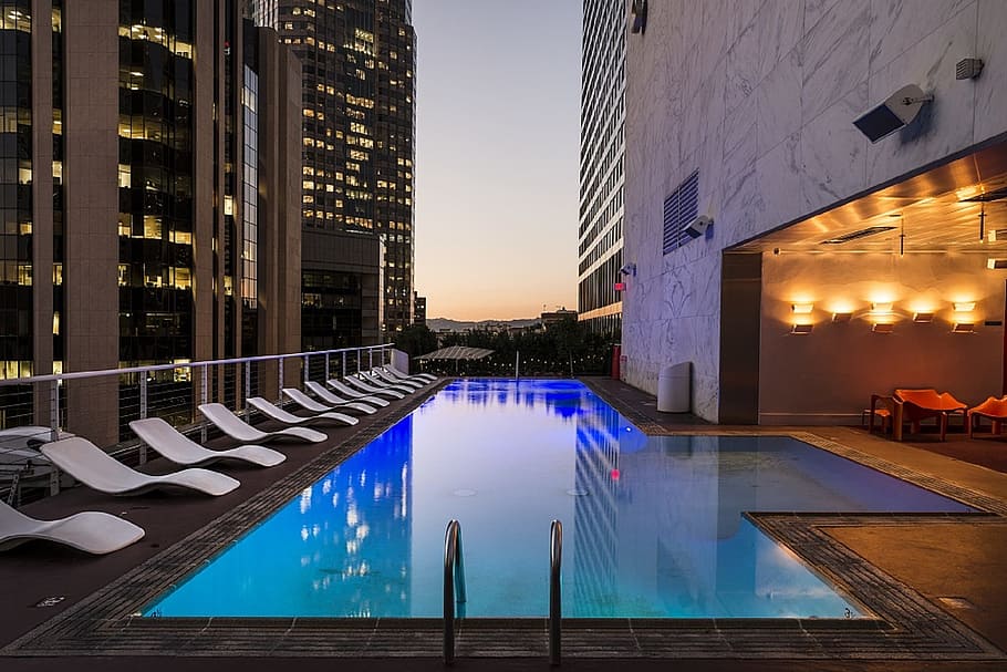 white, plastic lounges, pool, swimming, rooftop, hotel, downtown, city, los angeles, dusk