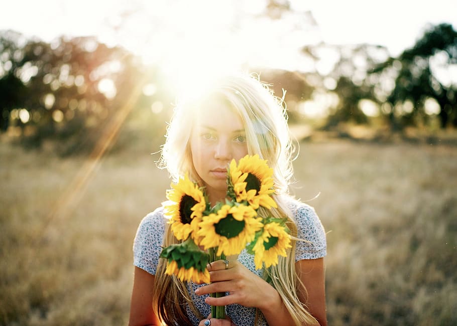 woman holding sunflower, beautiful, blond, blonde, field, flowers, girl, grass, outdoors, sun glare